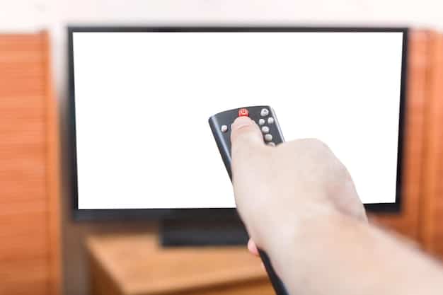 A close-up shot of a remote control pointing at a TV screen displaying the interface of a lesser-known streaming service, with a focus on the various genres and curated collections available. The image is well-lit and shows the user-friendly design of the service.