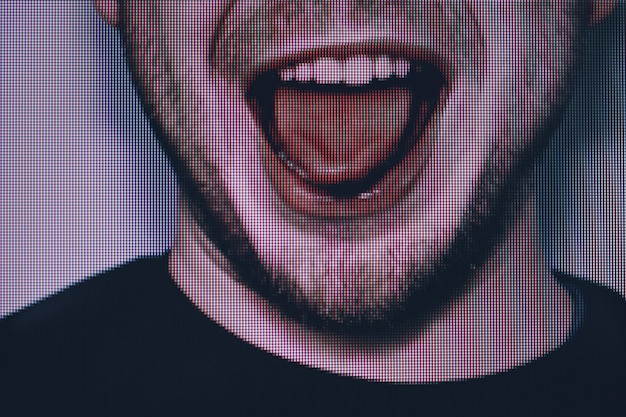 A close-up of a person dramatically covering their mouth with their hand, eyes wide in shock, with light suggesting they are in front of a TV screen.