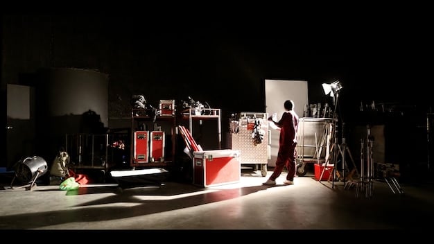 A wide shot of a dramatic scene, showcasing the set design and the use of lighting to create a specific mood, while characters are positioned strategically to convey their roles in the unfolding drama.