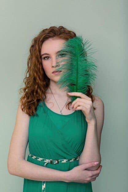 A scene from Bridgerton Season 3 where Penelope Featherington is dressed in a stunning emerald green gown. She has a determined look on her face.