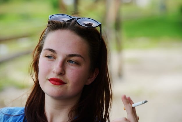 A close-up shot of Beth Dutton with a determined expression on her face, holding a cigarette. The background is blurred, suggesting a sense of isolation and focus.